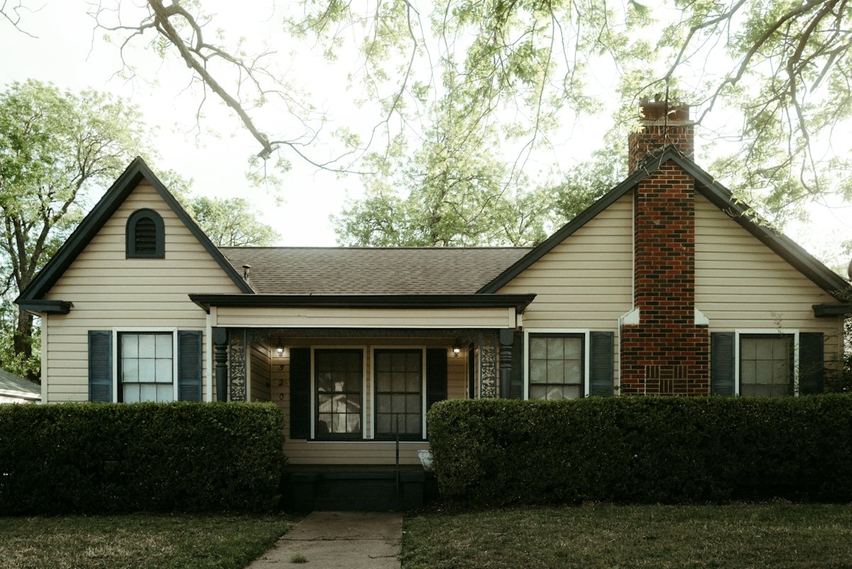 Brick house with a brick chimney and a green lawn